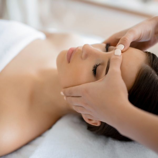 Calm girl having spa facial massage in luxurious beauty salon